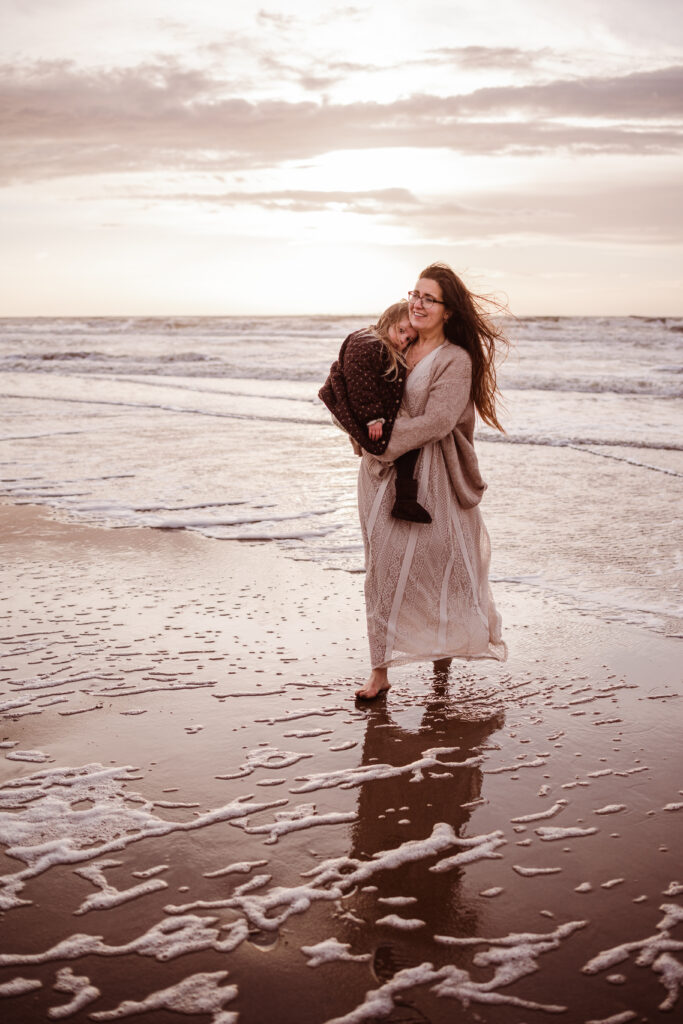 mamashoot motherhood kindershoot strand katwijk mama en dochter lopen in zee